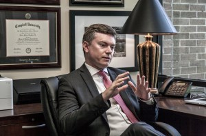 Lucien M. Roughton at his desk discussing a case